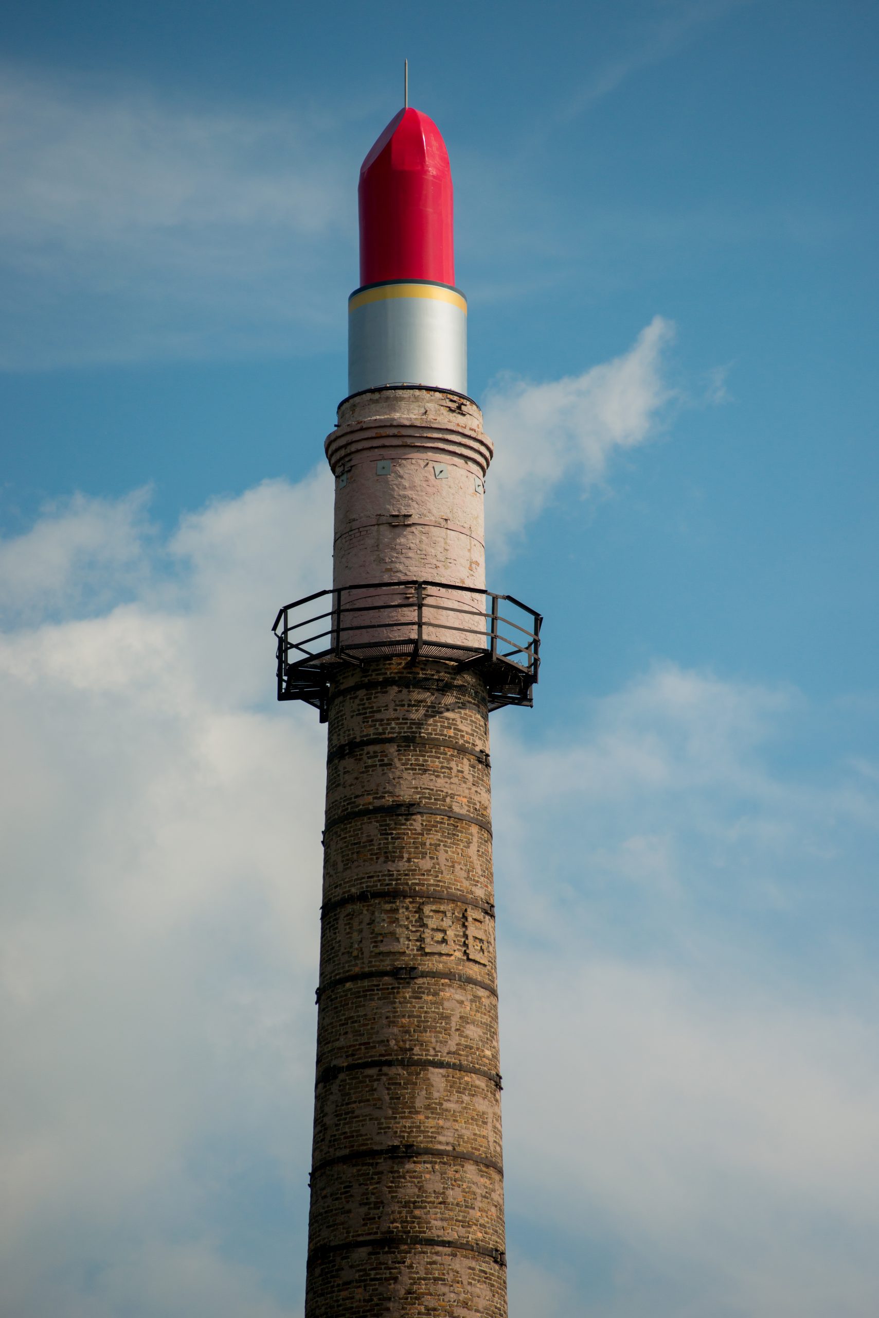 a defunct brick factory smokestack is transformed by an art installation into a giant tube of lipstick